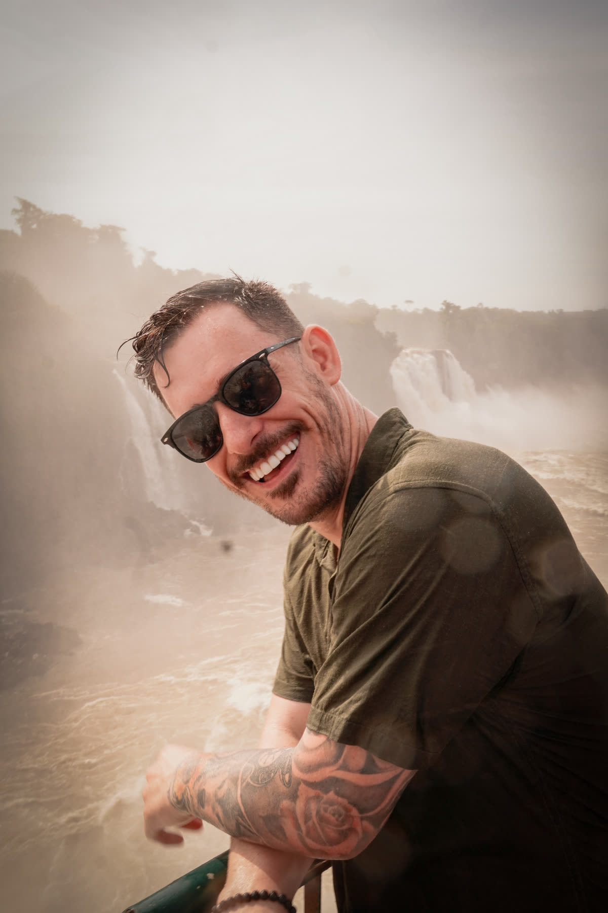 Renato sorrindo, de óculos escuros, diante das cataratas