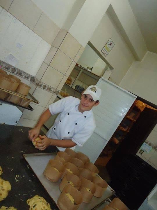 Renato bem jovem, de dólmã branca, sovando pão na padaria