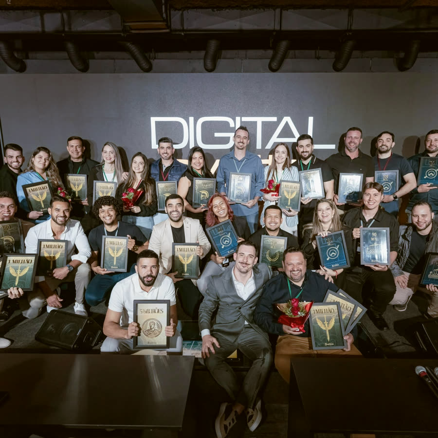 Turma de alunos no palco, cada um com a sua placa de faturamento