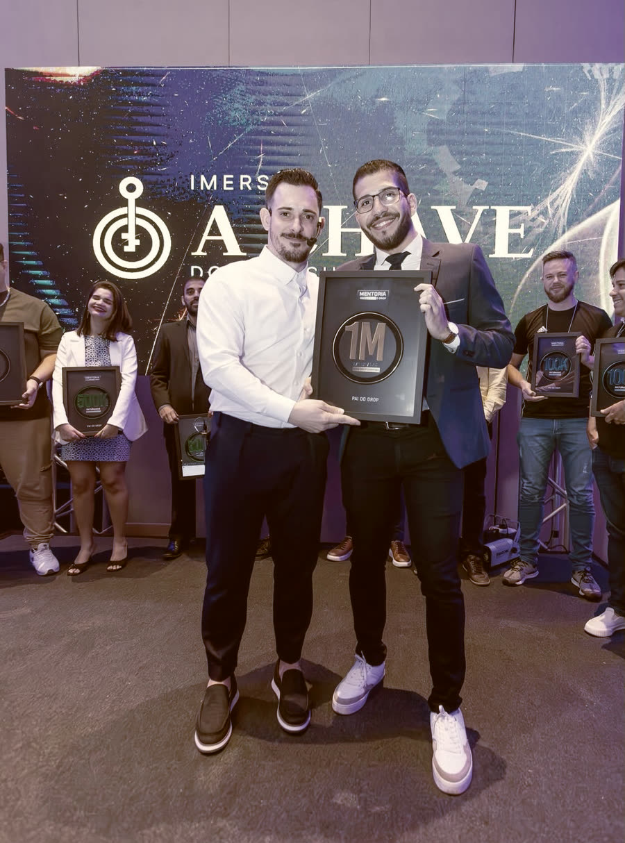 Renato entregando a placa de 1 milhão a um aluno no palco