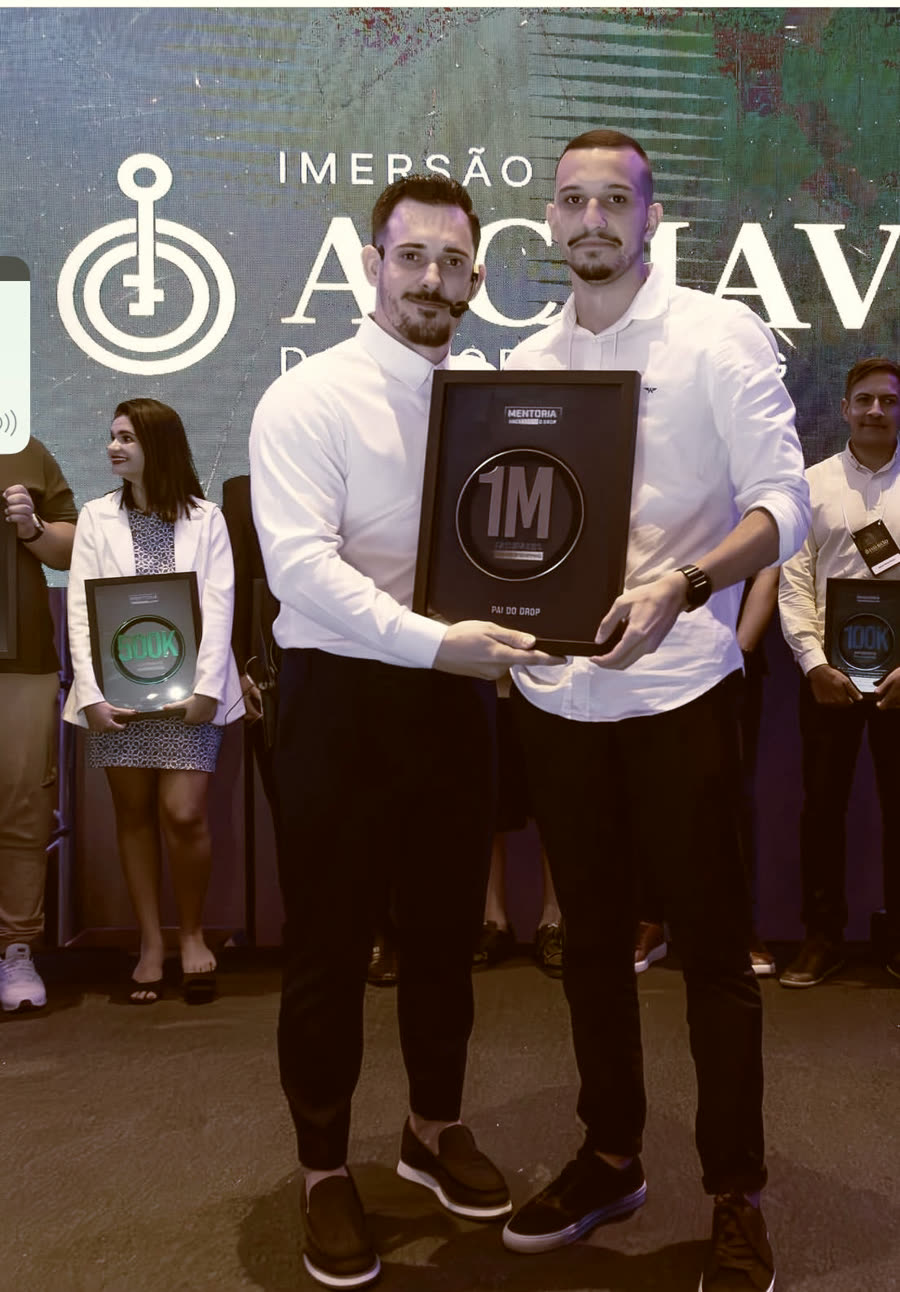 Renato e aluno segurando juntos a placa de 1 milhão