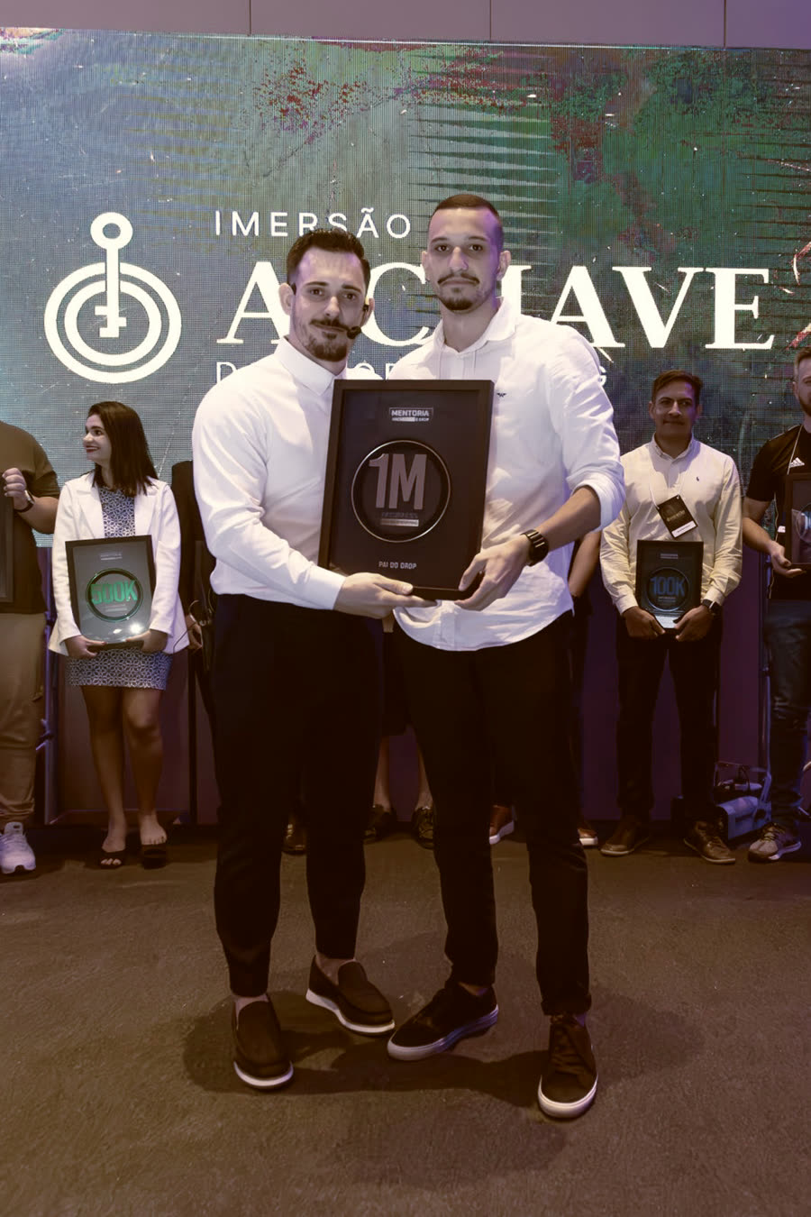 Aluno recebendo a placa de 1 milhão das mãos do Renato