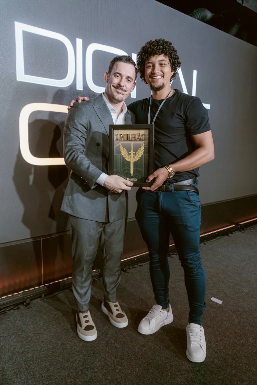 Aluno com a placa de faturamento ao lado do Renato
