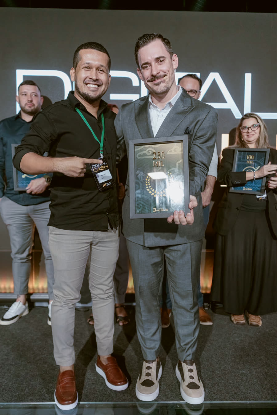 Aluno com a placa de faturamento ao lado do Renato