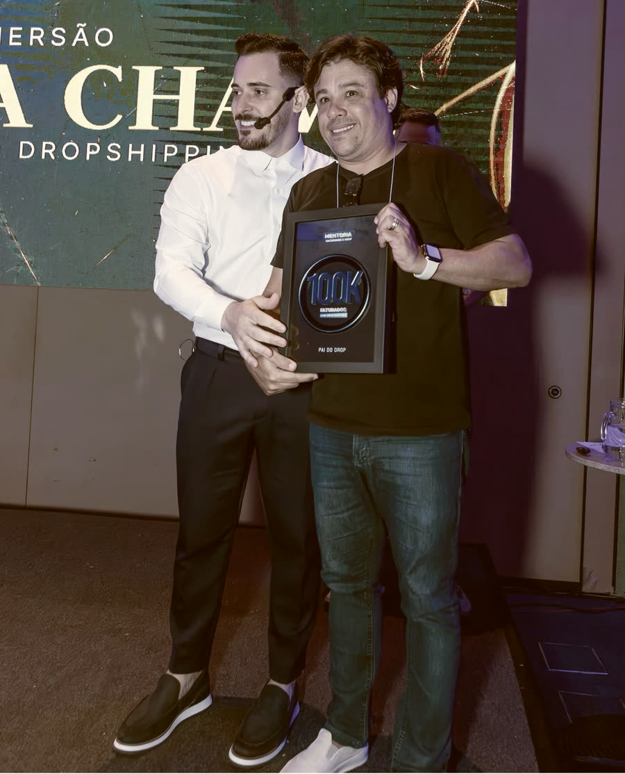 Aluno com a placa de faturamento ao lado do Renato